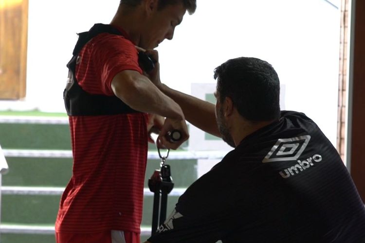 Pelatih kebugaran RCD Mallorca, Dani Pastor, sedang memasang sensor dalam sesi latihan di pusat kebugaran.