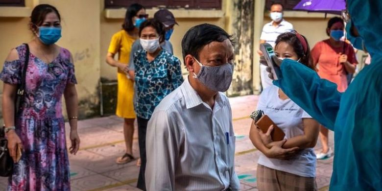 Dalam foto yang diambil di ibu kota Vietnam, Hanoi, orang-orang yang baru dari Da Nang mendapatkan tes Covid-19 setelah terjadi lonjakan kasus di sana.