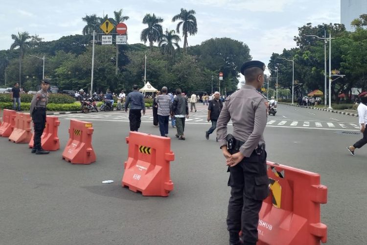Polisi melakukan pengalihan arus lalu lintas (lalin) tepat di Jalan Medan Merdeka Barat, Jakarta Pusat, imbas adanya demo pada Jumat (19/4/2024) siang. 