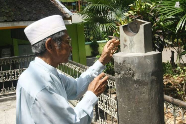 Takmir Masjid Al Huda, di Dusun Ngawinan, Desa Jetis, Kecamatan Bandungan, Kabupaten Semarang, KH Zaenal Muttaqin tengah membaca jam bencet untuk menentukan awal waktu salat zuhur, Sabtu (19/5/2018).