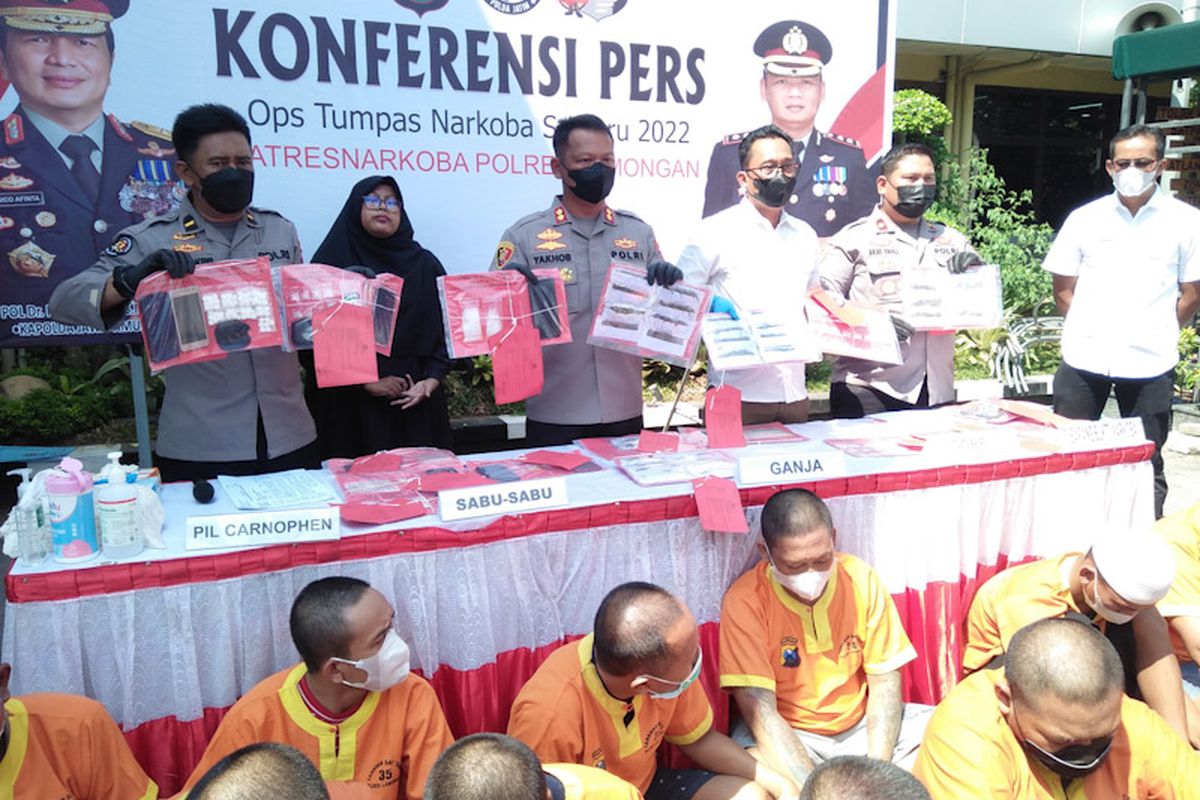 Pihak kepolisian menunjukkan barang bukti narkoba dan pengedar yang diamankan, saat rilis pengungkapan kasus di halaman Mapolres Lamongan, Selasa (13/9/2022).