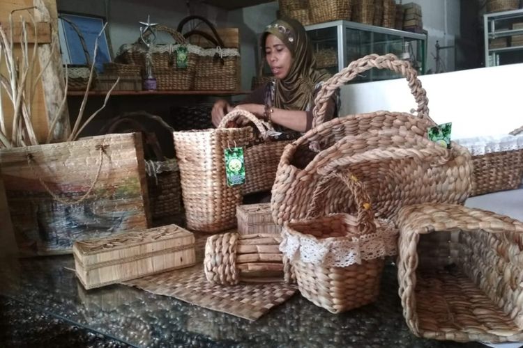 Sambinah (42) tengah menganyam vas bunga yang terbuat dari eceng gondok, Jumat (11/1/2019).Di tangan Sambinah (42), eceng gondok yang kerap dianggap sampah disulap menjadi produk bernilai ekonomis.