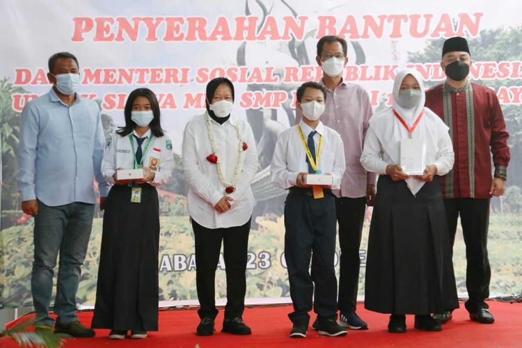 Menteri Sosial Tri Rismaharini didampingi Wali Kota Surabaya Eri Cahyadi memberikan bantuan sosial berupa tablet kepada 105 siswa tak mampu eks lokalisasi Dolly di SMPN 10 Surabaya, Sabtu (23/10/2021).