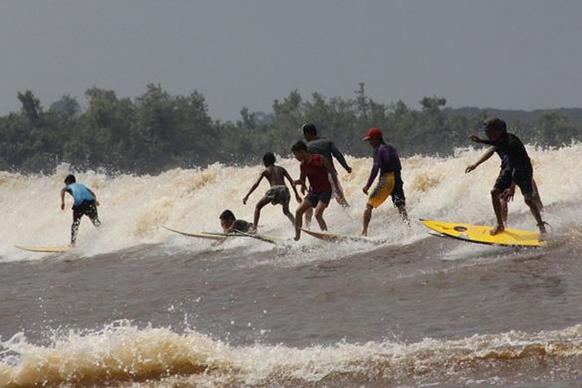 Local youth from Teluk Meranti Village, Teluk Meranti District, Pelalawan Regency, Riau, having fun enjoying the bono waves. They are no longer afraid to face the bono that was once called the seven ghosts.