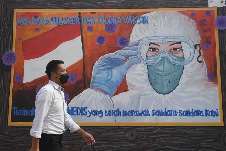 Warga melintas di dekat mural bertema COVID-19 di Jakarta, Rabu (1/12/2021). Menjelang liburan Natal dan Tahun Baru, Pemerintah kembali menaikkan status PPKM di DKI Jakarta menjadi level 2. ANTARA FOTO/Akbar Nugroho Gumay/wsj.