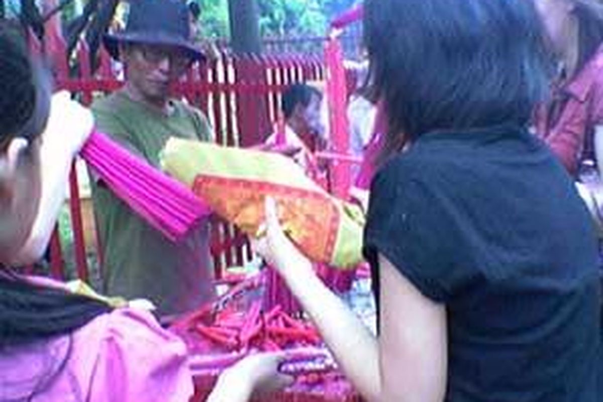 Lian Han Ciong alias Hans, tengah membantu umat yang akan membakar hio untuk sembahyang, di Klenteng Petak Sembilan, Glodok, Jakarta Barat, Kamis (7/2).