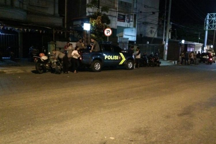 Polisi masih terlihat berjaga-jaga di Jalan Soetomo, Kecamatan Sirimau Ambon pasca tawuran dua kelompok warga di kawasan tersebut, Selasa malam (27/3/2018).