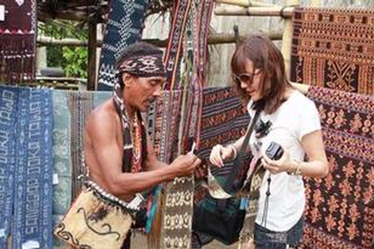 Olga Lydia menikmati tenunan khas Flores di Desa Doka.