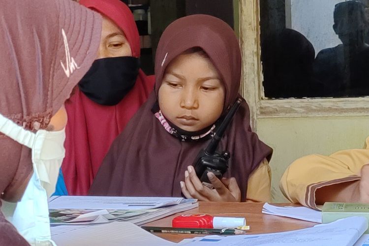 Almira Iismawardhani pelajar kelas 3 SD Negeri 2 Kanoman di Kalurahan Kanoman, Kapanewon Panjatan, Kulon Progo, Daerah Istimewa Yogyakarta. Ia menerima pengajaran Bahasa Jawa dari gurunya dengan menggunakan handytalkie sebagai media komunikasi. Menurutnya, cara ini irit dan cepat selesai.