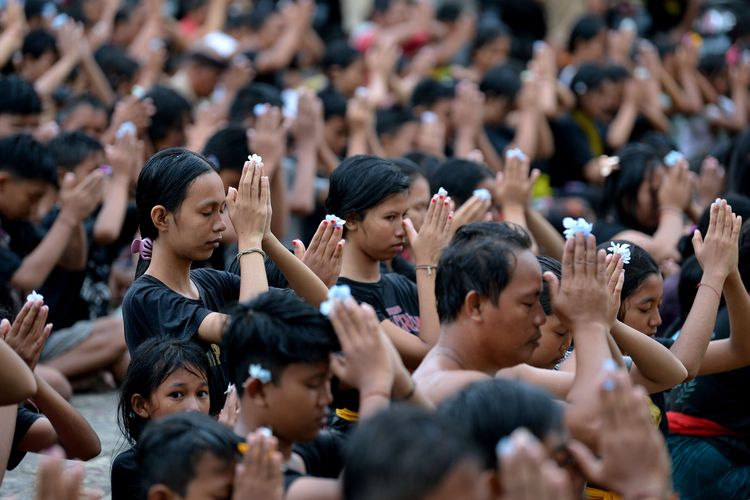 Sejumlah warga bersembahyang bersama saat mengikuti tradisi Mebuug-Buugan atau mandi lumpur di Desa Kedonganan, Badung, Bali, Kamis (23/3/2023). Tradisi Mebuug-Buugan yang dilakukan setelah Hari Raya Nyepi tersebut dilakukan sebagai simbol menghilangkan kekotoran atau hal-hal negatif.