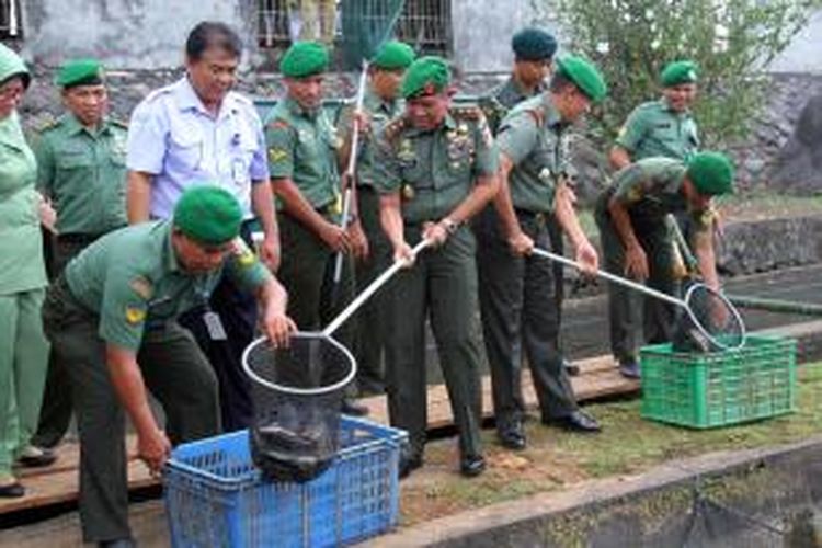Panglima Kodam (Pangdam) VII/Wirabuana, Mayor Jenderal (Mayjen) TNI Bactiar, memanen ikan di Lokasi Ketahanan Pangan milik TNI-AD di desa Tateli, Minahasa.