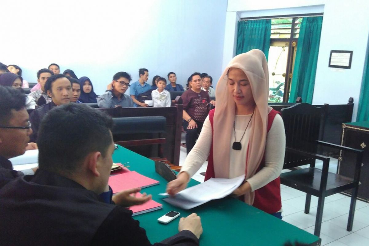 Dewi Aminah, saat menyerahkan berkas pembelaan kepada kuasa hukum dalam sidang di PN Mataram, Senin (10/4/2017).