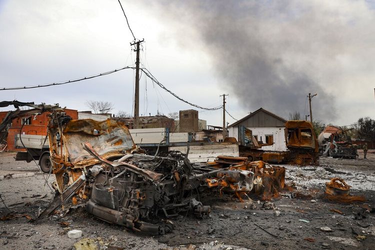 Kendaraan yang terbakar terlihat di bagian yang hancur dari Pabrik Metalurgi Illich Iron & Steel Works, saat asap mengepul dari Metallurgical Combine Azovstal selama pertempuran sengit, di daerah yang dikendalikan oleh pasukan separatis yang didukung Rusia di Mariupol, Ukraina, Senin, 18 April, 2022.