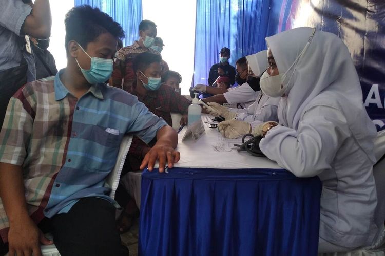 Salah satu peserta vaksinasi menjalani pemeriksaan medis sebelum disuntik vaksin Covid-19. Kegiatan vaksinasi tersebut berlansung di Kompleks GOR Bung Karno Nganjuk, Kamis (23/9/2021).