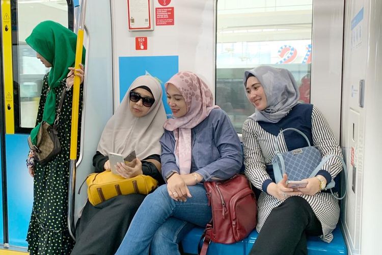 Ibu-ibu muda menggunakan MRT Jakarta