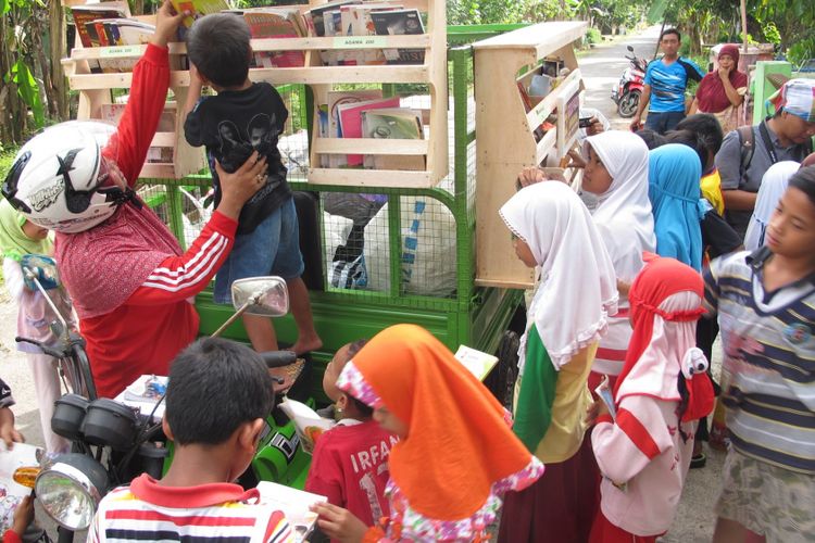 Pegiat Limbah Pustaka, Raden Roro Hendarti berkeliling dengan perpustakaan motor roda tiga di Desa Muntang, Kecamatan Kemangkon, Purbalingga, Jawa Tengah,  Rabu (17/5/2017)