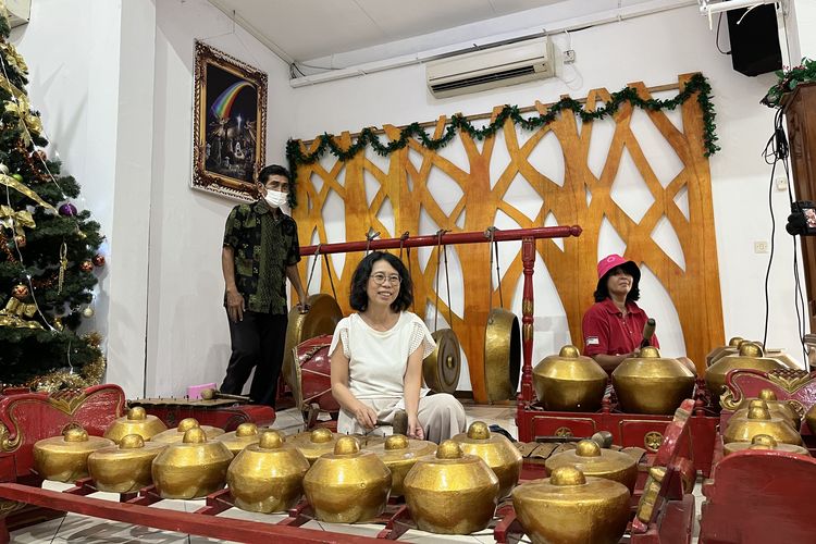 Peserta tur wisata mencoba bermain gamelan di Gereja Kristen Jawa Tanjung Priok, Jakarta Utara, Minggu (24/12/2023).