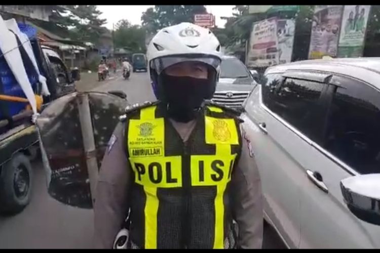 Salah Satu Petugas Tim Urai Polres Bangkalan yang Sedang Melakukan Rekayasa Lalulintas di Pertigaan Pasar Tumpah Tanah Merah,