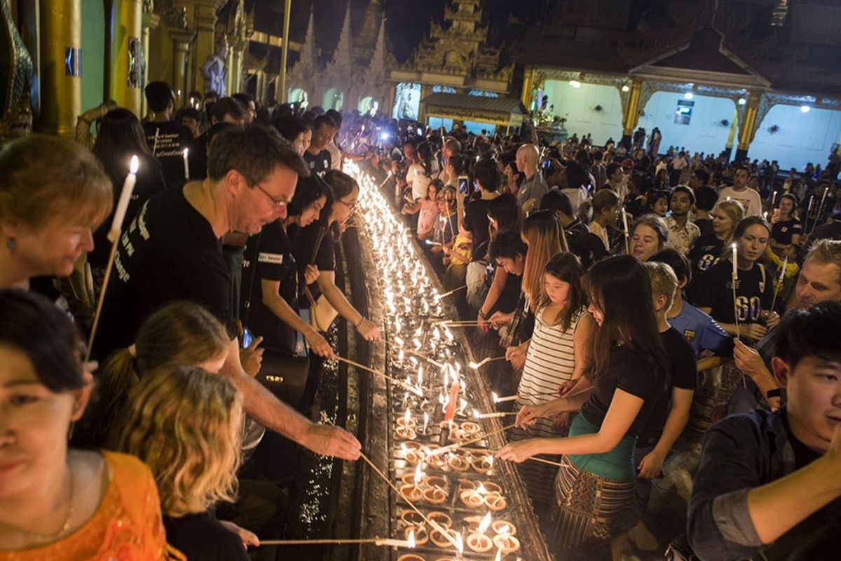 Seseorang menyalakan lampu minyak pada peringatan Earth Hour yang pertama kalinya di Myanmar, berlokasi di Pagoda Shwedagon, Yangon, Sabtu (25/3/2017).