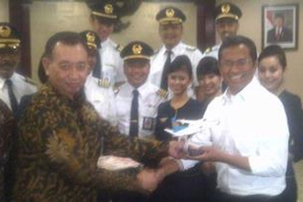 Pjs Direktur Utama Merpati Nusantara Airline Rudy Setyopurnomo saat memberikan suvenir kepada Menteri Negara BUMN Dahlan Iskan di Kementerian BUMN Jakarta, Kamis (19/7/2012).