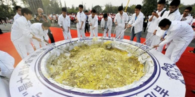 Sekitar 300 pemasak bergiliran mengaduk nasi goreng khas Yangzhou dalam upaya memecahkan rekor. 