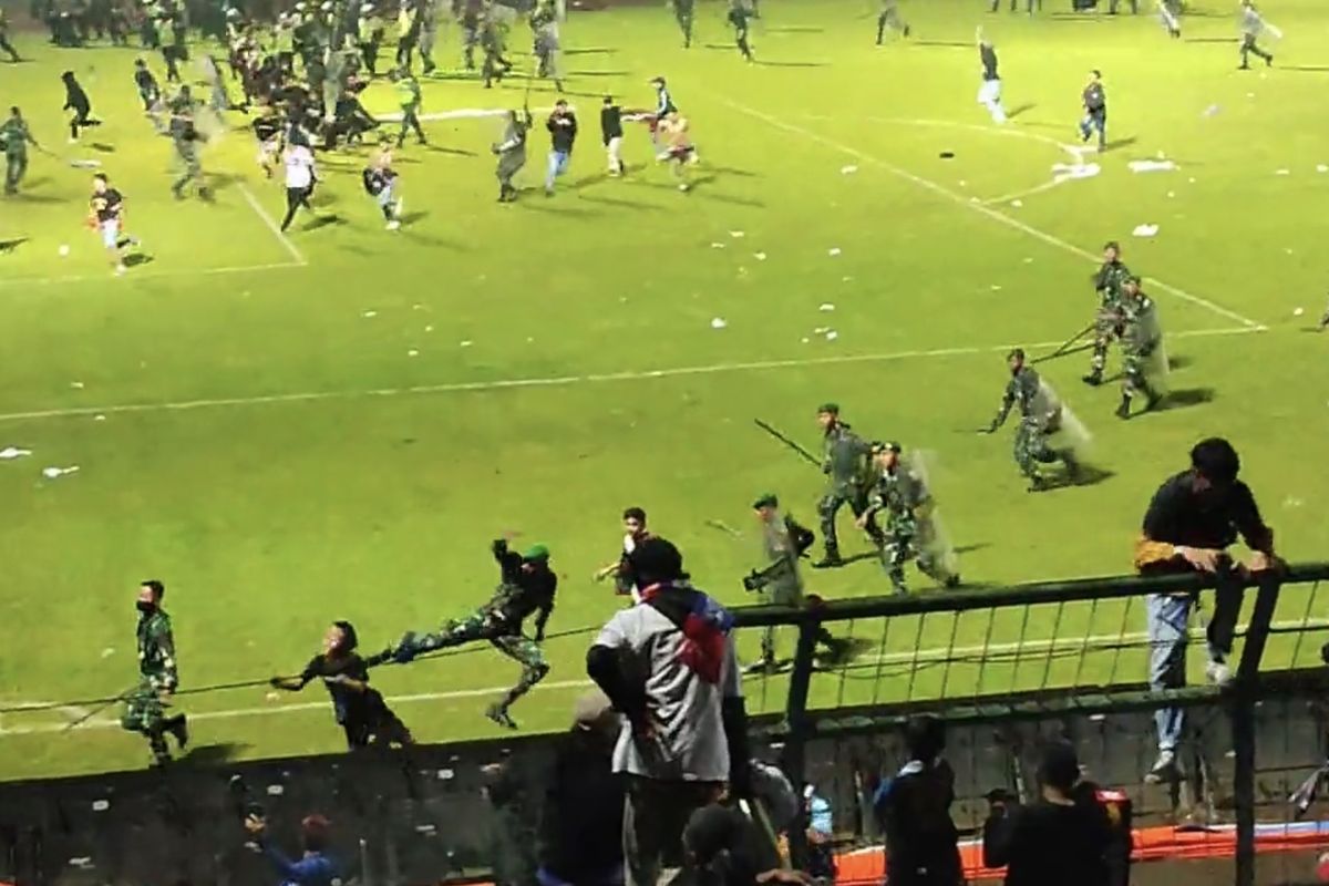 Seorang prajurit melakukan tendangan “kungfu” terhadap seorang remaja suporter Arema FC pada tragedi di Stadion Kanjuruhan, Malang, Jawa Timur, Sabtu (1/10/2022).