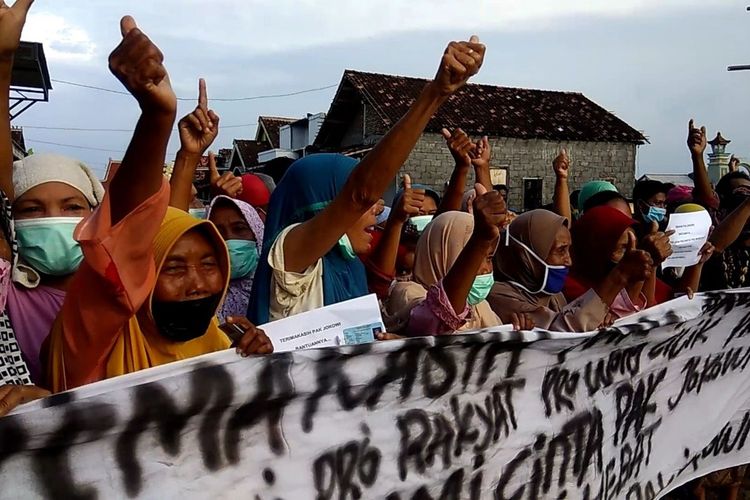 Ibu-ibu warga Bandengan Kendal, saat membentangkan spanduk ucapan terima kasih kepada presiden Jokowi. KOMPAS.COM/SLAMET PRIYATIN