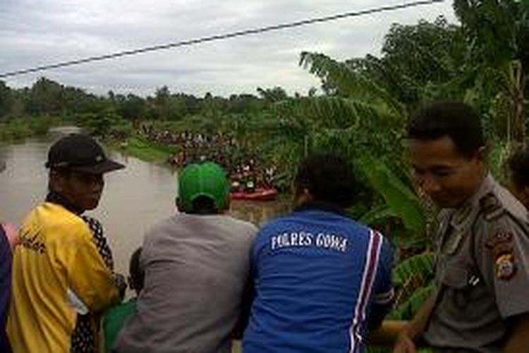 Ratusan warga di Kabupaten Gowa, Sulawesi Selatan menyaksikan proses pencarian seorang pelajar Sekolah Menengah Pertama (SMP) yang diketahui hanyut terbawa arus sungai saat mencari kepiting. Kamis, (29/01/2015).