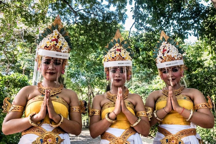 Ilustrasi - Penari Kecak di Uluwatu, Bali, menggunakan face shield saat pentas. 