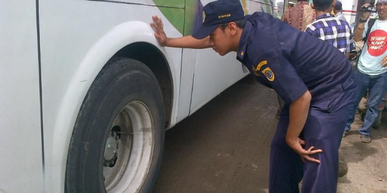 Petugas dari Dinas Perhubungan Brebes, Jawa Tengah, melakukan cek ban bus dalam rangka sidak kelaikan jalan di Terminal Tanjung, Selasa (24/12/2013).
 