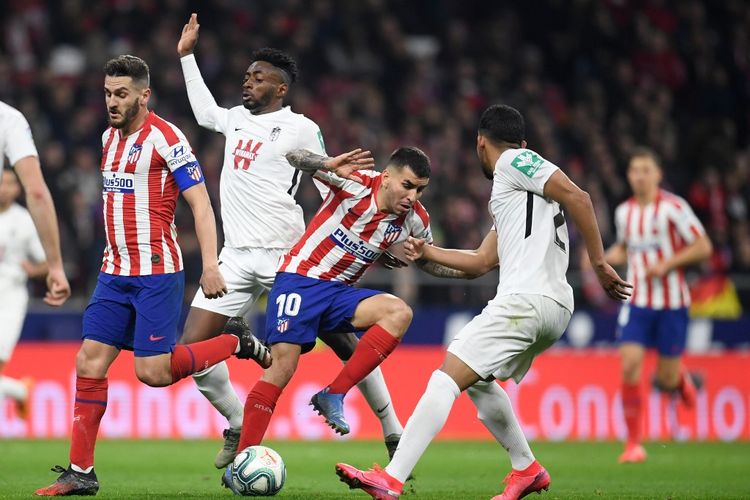 Gelandang Granada asal Kamerun Yan Eteki (2L) bersaing dengan pemain tengah Atletico Madrid asal Spanyol Koke (kiri) dan pemain depan Atletico Madrid asal Argentina Angel Correa (2R) selama pertandingan sepak bola liga Spanyol antara Club Atletico de Madrid dan Granada FC di stadion Wanda Metropolitano di Madrid. 8 Februari 2020. (Foto oleh OSCAR DEL POZO / AFP)