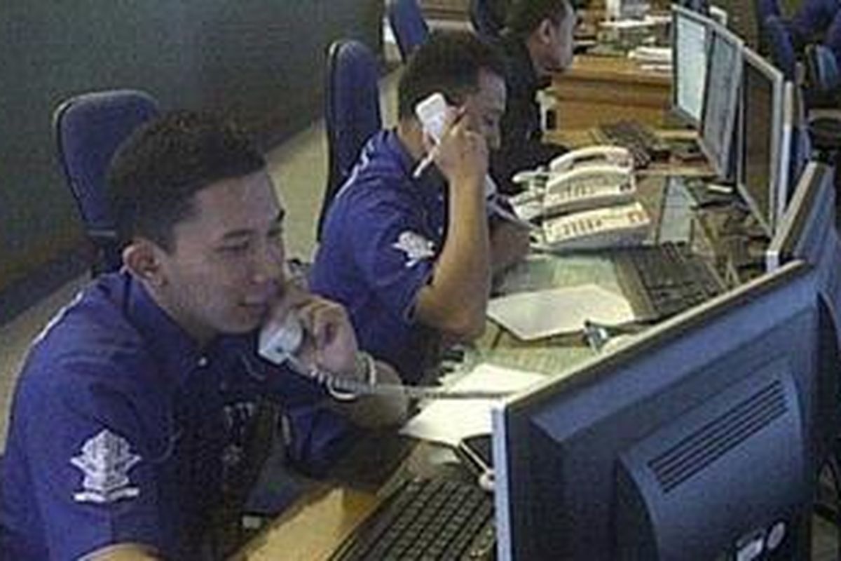 Ilustrasi : Brigadir Satu Tatak saat bertugas di Call Center TMC didampingi rekan kerjanya.