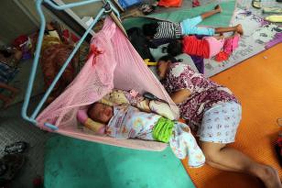 Bayi menangis saat mengungsi di Halte Transjakarta Jembatan Baru, Jakarta Barat, Senin (20/1/2014). Ratusan warga terpaksa mengungsi di tempat tersebut karena rumahnya terendam banjir. Banjir masih menggenangi sejumlah kawasan di Jakarta yang membuat puluhan ribu warga terdampak terpaksa mengungsi. WARTA KOTA/ANGGA BHAGYA NUGRAHA