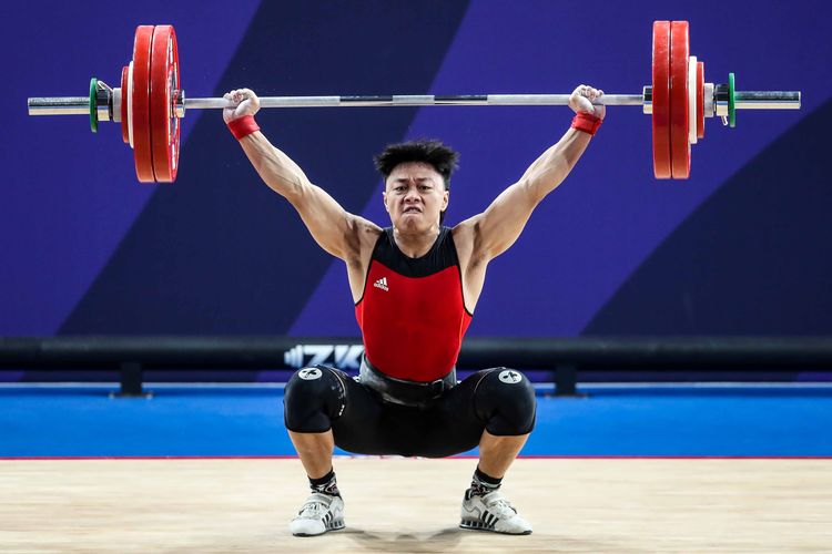 Lifter putra Indonesia, Rahmat Erwin Abdullah mengangkat beban pada kelas 73 kilogram putra di Ninoy Aquino Memorial Stadium, Manila, Filipina, Rabu (4/12/2019). Rahmat Erwin Abdullah menyumbang medali emas dan menorehkan total angkatan terbaik seberat 322 kilogram.