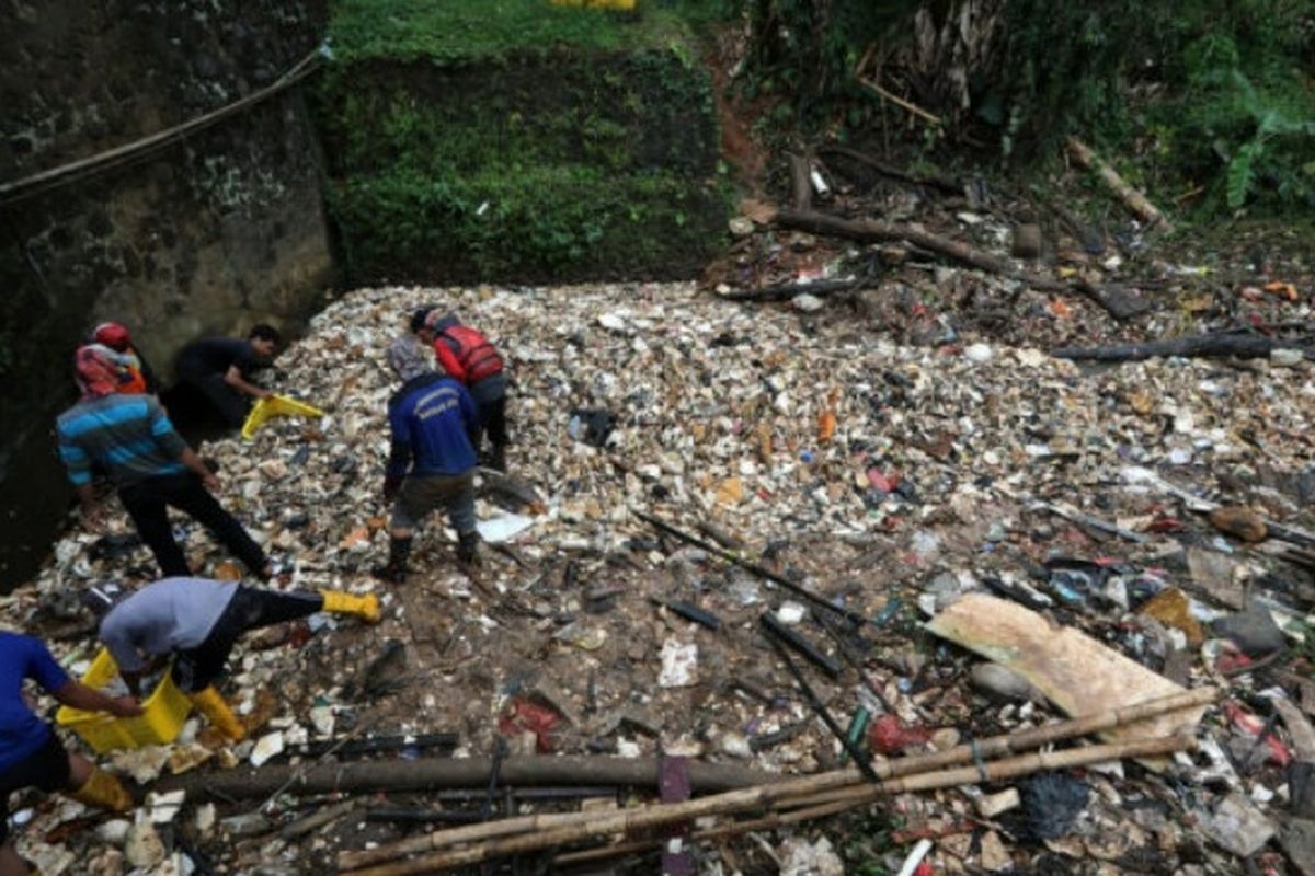Petugas membersihkan aliran Kali Baru, Cimanggis, Depok, Jawa Barat yang tertutup sampah sepanjang kira-kira 300 meter. Namun, akibat sempitnya akses masuk menuju lokasi, alat berat belum dapat diterjunkan sehingga pengangkutan sampah masih dilakukan secara manual.