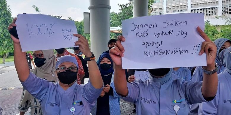 Para pegawai RSUP Dr Sardjito Yogyakarta saat berjalan sembari membawa poster. Para pegawai ini memprotes diberikanya THR 30 persen dari besaran insentif.