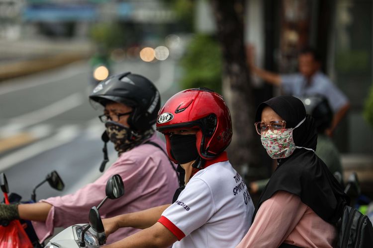 Warga menggunakan masker saat mengendarai sepeda motor di kawasan Mampang Prapatan, Jakarta Selatan, Senin (6/4/2020). Kebijakan wajib masker itu  tertuang dalam Seruan Gubernur Daerah Khusus Ibu Kota Jakarta Nomor 9 Tahun 2020 Tentang Penggunaan Masker Untuk Mencegah Penularan Corona Virus Disease (Covid-19).