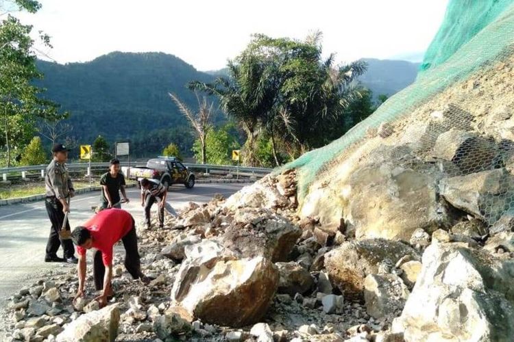 Petugas tengah menyingkirkan material longsor dari tebing tanjakan Mala di Naringgul, Kabupaten Cianjur, Jawa Barat, yang sempat menutup badan jalan, Minggu (12/01/2020)