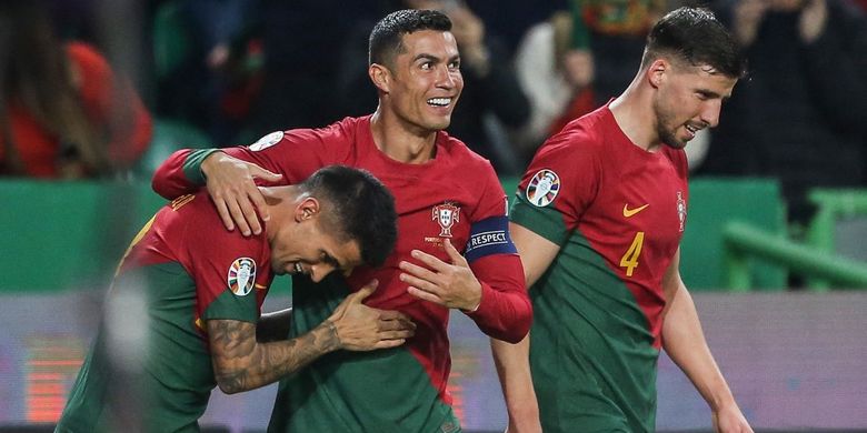 Cristiano Ronaldo (tengah) merayakan gol yang dicetak Joao Cancelo (kiri) dalam laga Kualifikasi Euro 2024 antara Portugal vs Liechtenstein di Stadion Jose Alvalade, Lisbon, 23 Maret 2023. Selanjutnya, Portugal bakal melawan Luksemburg dalam matchday kedua Kualifikasi Euro 2024. Laga Luksemburg vs Portugal bergulir di Stadion Luxembourg pada Senin (27/3/2023) mulai pukul 01.45 WIB. Artikel ini berisi prediksi Portugal vs Slovakia.(Photo by CARLOS COSTA / AFP)