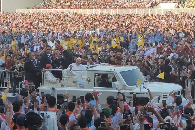 Paus Fransiskus menyapa ribuan umat Katolik di Stadion Madya, Gelora Bung Karno, Kamis (5/9/2024), dengan melakukan satu putaran mengelilingi stadion menggunakan mobil Maung Pindad beratap terbuka. 