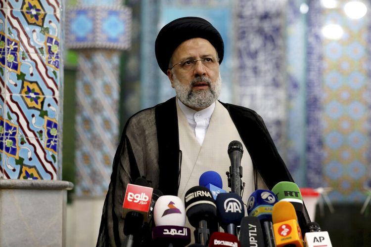 Calon presiden Iran Ebrahim Raisi melambai ke media setelah memberikan suaranya di tempat pemungutan suara di Teheran, Iran, Jumat (18/6/2021). Iran menggelar pemungutan suara dalam pemilihan presiden pada Jumat.