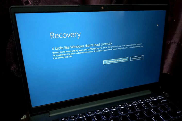 Ilustrasi laptop Windows mengalami error layar biru atau Blue Screen of Death (BSOD).
 