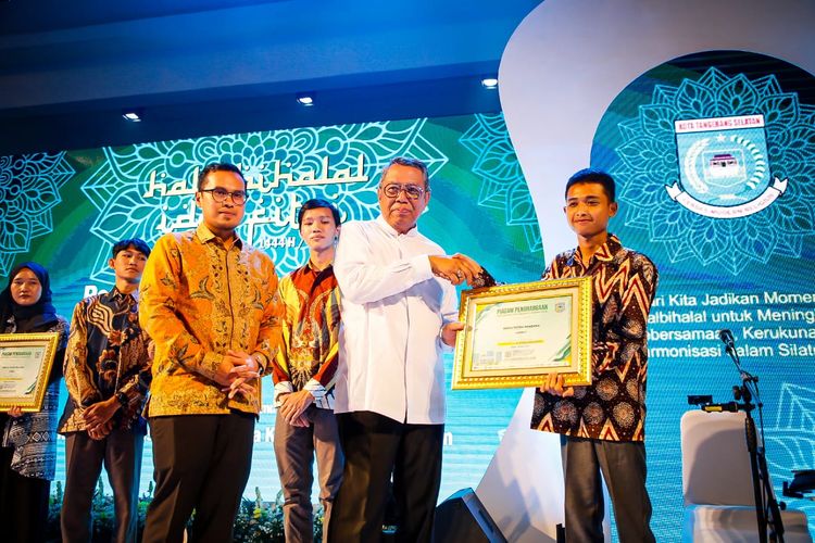 Wali Kota Tangerang Selatan (Tangsel) Benyamin Davnie saat menyerahkan penghargaan kepada pemenang Olimpiade Cyber Security Hacking dari berbagai wilayah di Indonesia bersamaan dengan acara halalbihalal di Plaza Puspemkot Tangsel, Rabu (11/5/2023).
