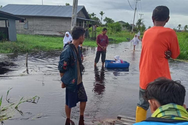Sejumlah anak-anak menerjang banjir untuk pergi ke sekolah di Desa Kuala Sebatu, Kecamatan Batang Tuaka, Kabupaten Inhil, Riau, Senin (1/11/2022).