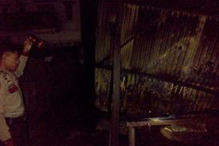 Seorang petugas polisi tengah memeriksa puing-puing, bekas lokasi kebakaran yang menimpa sebuah rumah makan ikan bakar Anakia di Jalan Brigjen Madjid  Joenos, Kelurahan Bende, Kecamatan Baruga, Kota Kendari, Sulawesi Tenggara, Minggu malam.  