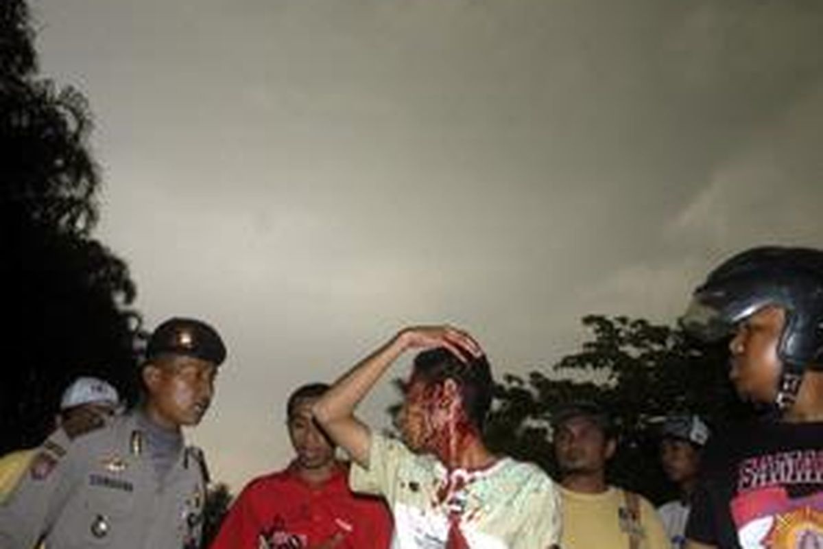 Seorang mahasiswa Suryadharma dievakuasi polisi setelah menjadi sasaran amuk warga di Kampung Pulo, Minggu (27/7).
