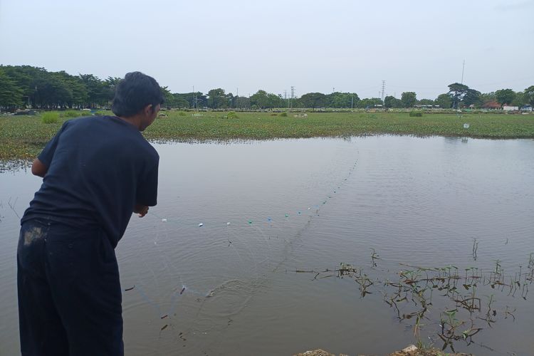 Dari Bekasi, Roni Datang Menjaring Ikan di TPU Semper yang Terendam Banjir