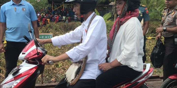 Presiden Joko Widodo memboncengi Ibu Negara Iriana saat blusukan di Kota Agats, Kabupaten Asmat, Provinsi Papua, Kamis (12/4/2018).