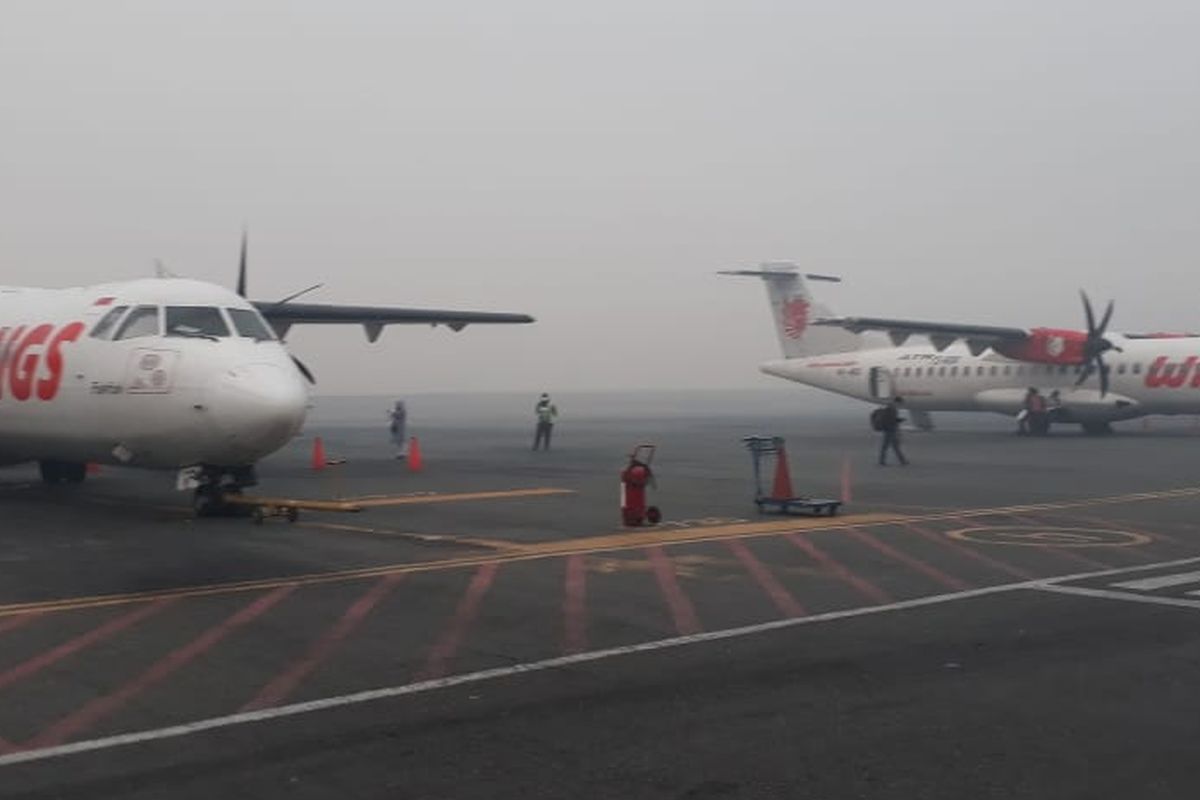 Dua dari tujuh pesawat yang mengalami penundaan keberangkatan akibat tebalnya kabut asap di Bandara Syamsuddin Noor, Banjarmasin, Kalsel, Minggu (15/9/2019).