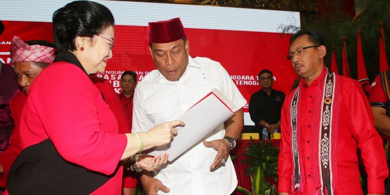 Ketua Umum PDIP Megawati Soekarnoputri (kiri) menyerahkan surat rekomendasi kepada pasangan bakal calon gubernur dan wakil gubernur Maluku Murad Ismail (tengah) dan Barnabas Orno (kanan) seusai mengumumkan bakal calon gubernur dan wakil gubernur empat daerah di DPP PDIP, Jakarta, Minggu (17/12). PDIP resmi mengusung pasangan Arsyadjuliandi Rachman-Suyatno pada Pilgub Riau, Asrun-Hugua pada Pilgub Sulawesi Tenggara, Marianus Sae-Emilia Nomleni pada Pilgub NTT, dan Murad Ismail-Barnabas Orno pada Pilgub Maluku. ANTARA FOTO/Rivan Awal Lingga/ama/17